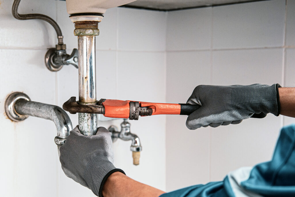 technician plumber using a wrench to repair water pipe 1024x683 1.jpg